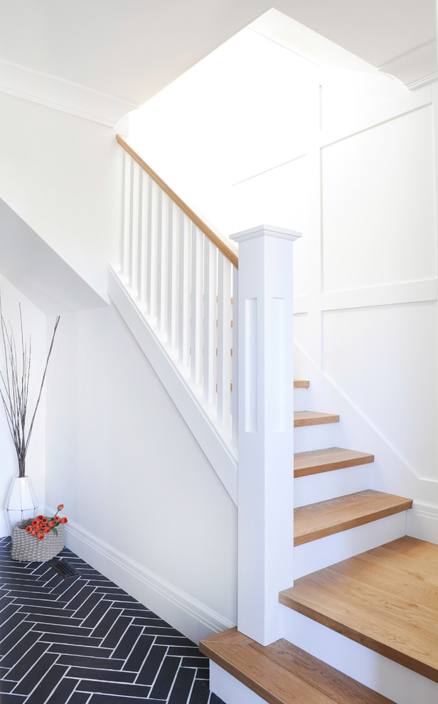 Staircase - mid-sized transitional wooden l-shaped wood railing and wall paneling staircase idea in Vancouver with painted risers