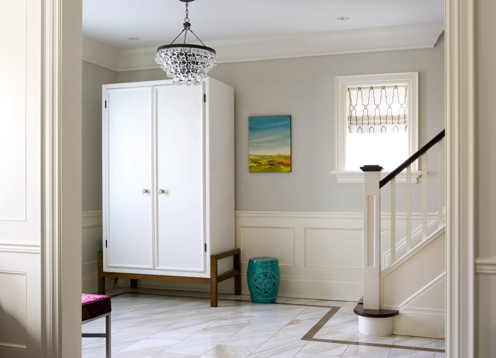 Idée de décoration pour un hall d'entrée tradition de taille moyenne avec un mur gris.