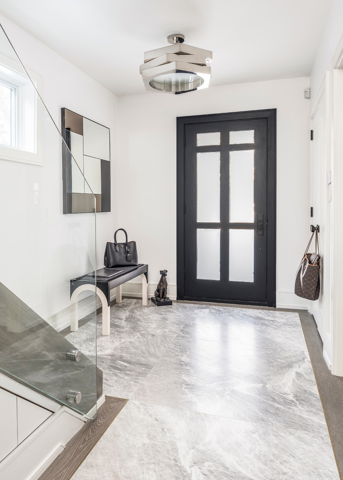 トロントにある高級な中くらいなモダンスタイルのおしゃれな玄関ロビー (白い壁、大理石の床、黒いドア、グレーの床) の写真