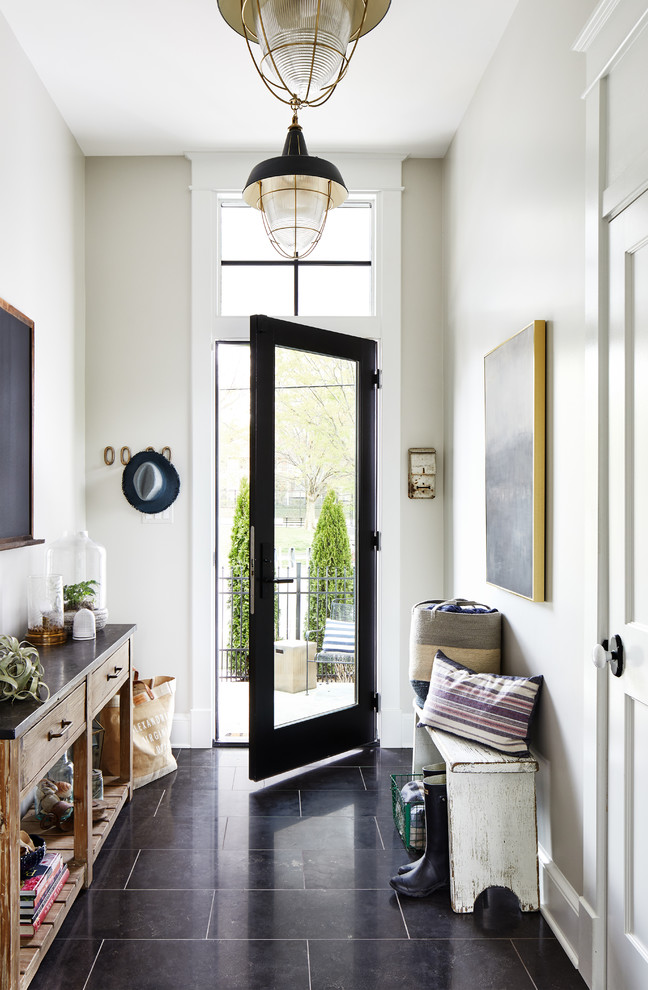 Foto de hall costero con paredes beige, puerta simple, puerta de vidrio y suelo negro