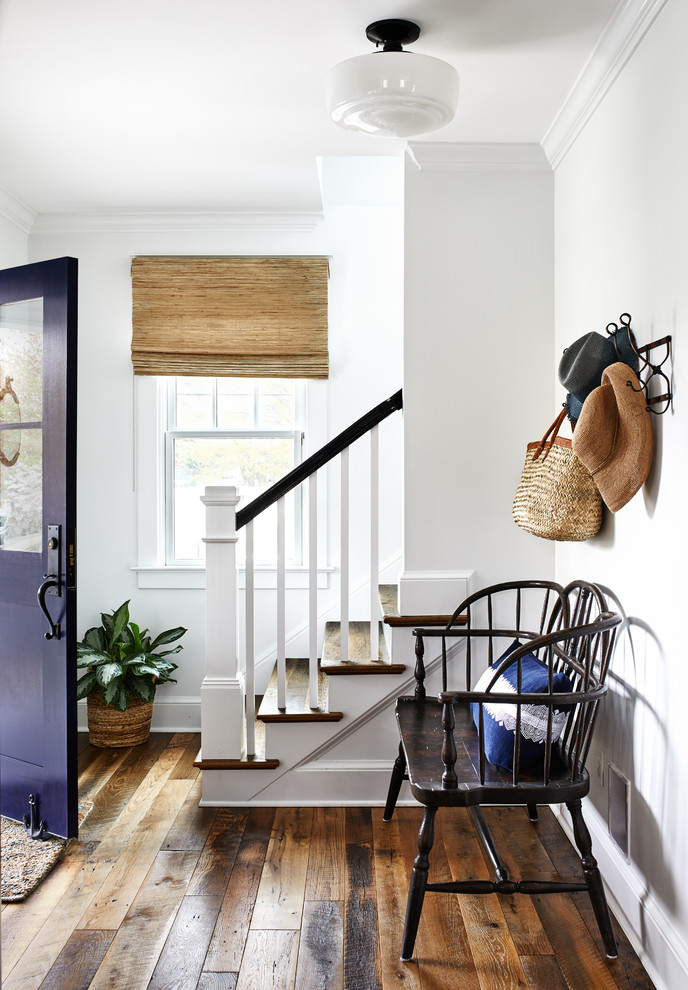 Esempio di un corridoio stile marino con pareti bianche, pavimento in legno massello medio, una porta singola, una porta viola e pavimento marrone