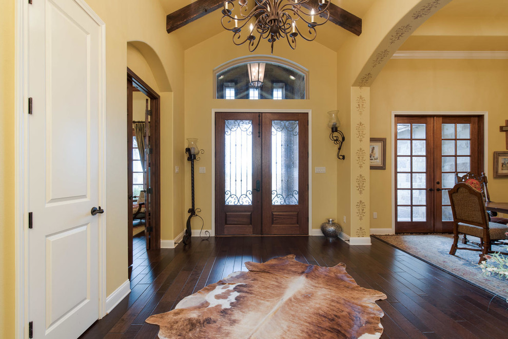 Geräumiges Rustikales Foyer mit beiger Wandfarbe, braunem Holzboden, Doppeltür und schwarzer Haustür in Austin