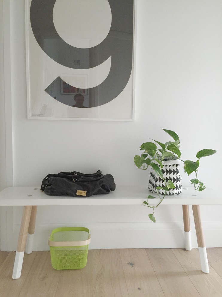 Idéer för att renovera en mycket stor minimalistisk foajé, med vita väggar, ljust trägolv och en enkeldörr