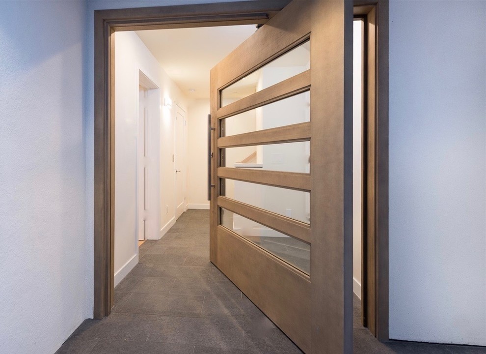 Идея дизайна: входная дверь среднего размера в современном стиле с белыми стенами, бетонным полом, поворотной входной дверью, входной дверью из светлого дерева и серым полом