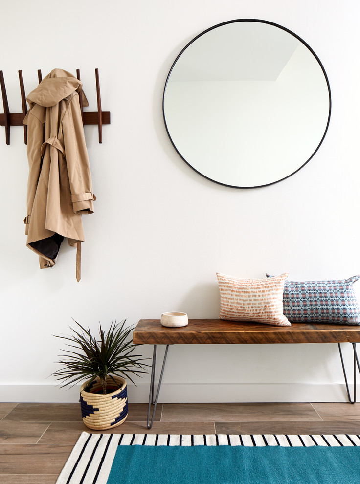 Design ideas for a small contemporary foyer in DC Metro with white walls, porcelain flooring and brown floors.