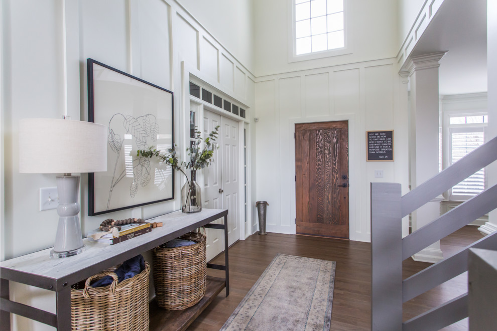 Inspiration for a rural foyer in Atlanta with white walls, medium hardwood flooring, a single front door, a medium wood front door, brown floors and feature lighting.