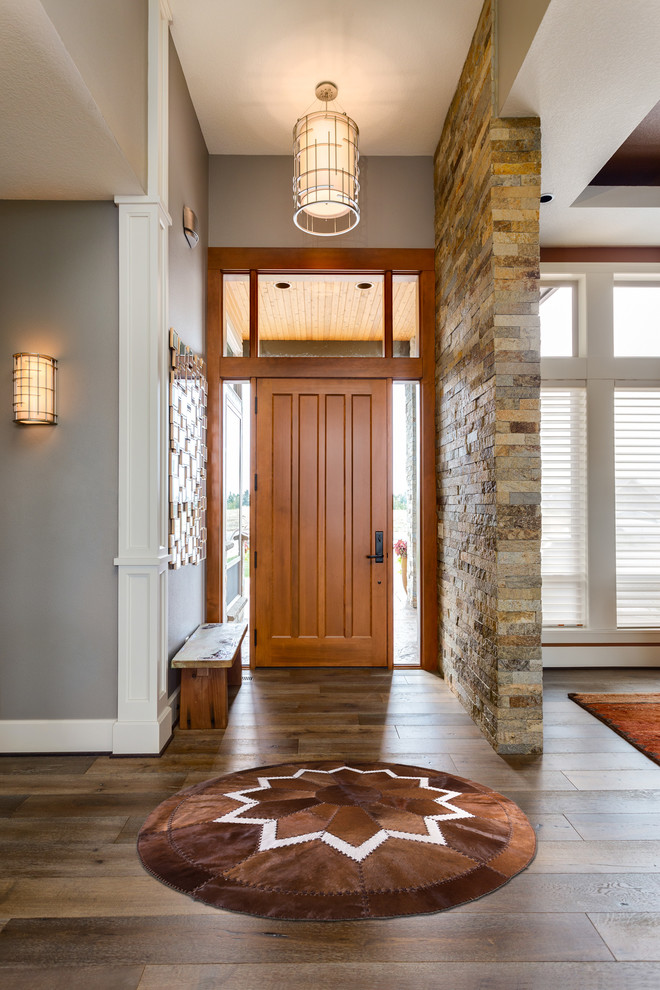 Пример оригинального дизайна: фойе среднего размера в стиле неоклассика (современная классика) с серыми стенами, паркетным полом среднего тона, одностворчатой входной дверью, входной дверью из дерева среднего тона и коричневым полом