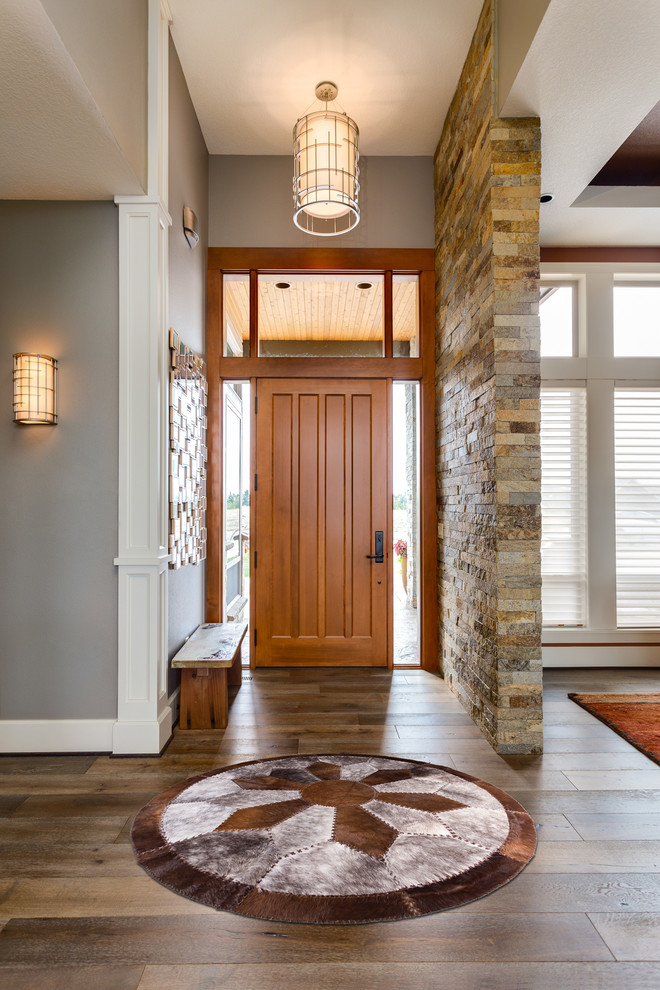 Example of a mid-sized transitional medium tone wood floor and brown floor entryway design in Los Angeles with gray walls and a medium wood front door