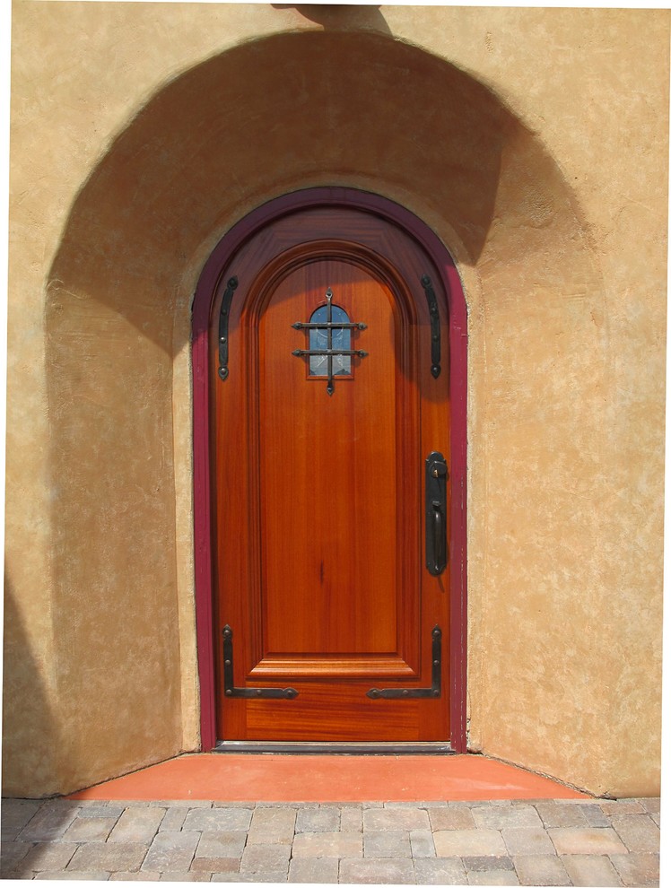 Стильный дизайн: входная дверь среднего размера в средиземноморском стиле с бежевыми стенами, бетонным полом, одностворчатой входной дверью и входной дверью из дерева среднего тона - последний тренд