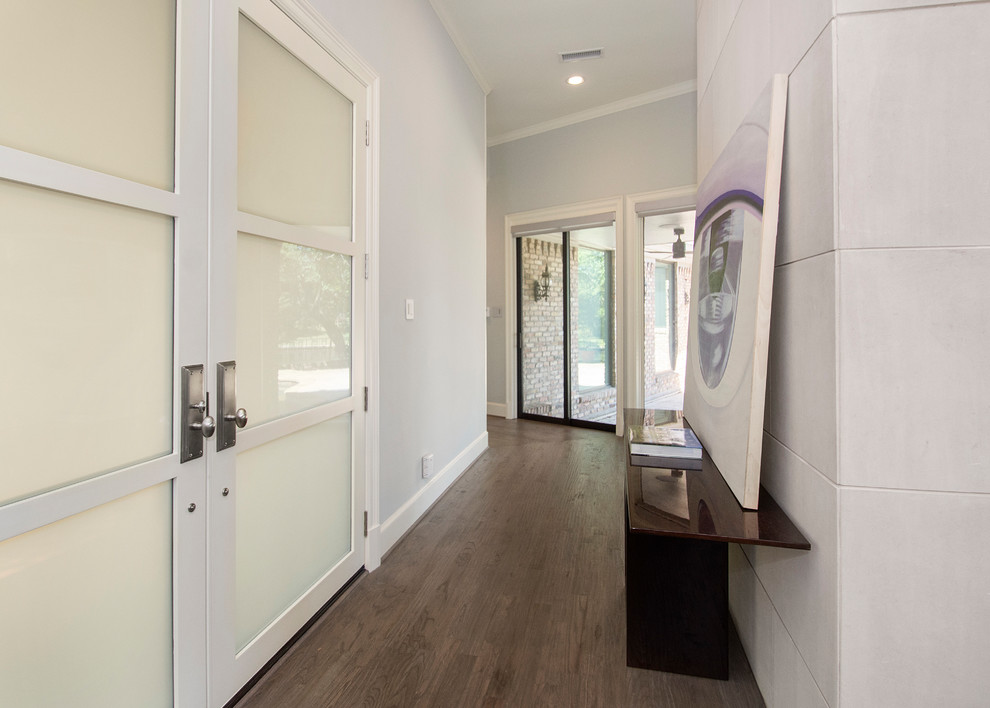 Immagine di una porta d'ingresso minimal di medie dimensioni con pareti grigie, pavimento in legno massello medio, una porta a due ante, una porta in vetro e pavimento marrone