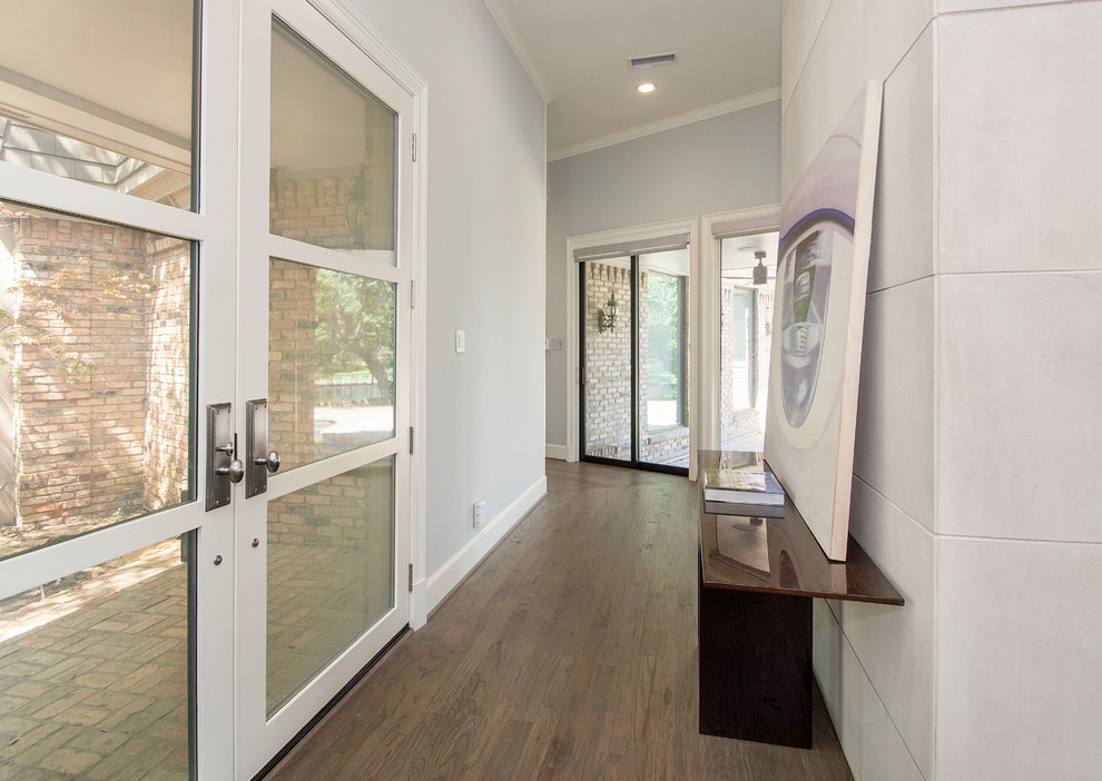 Modelo de puerta principal actual de tamaño medio con paredes grises, suelo de madera en tonos medios, puerta doble y puerta de vidrio