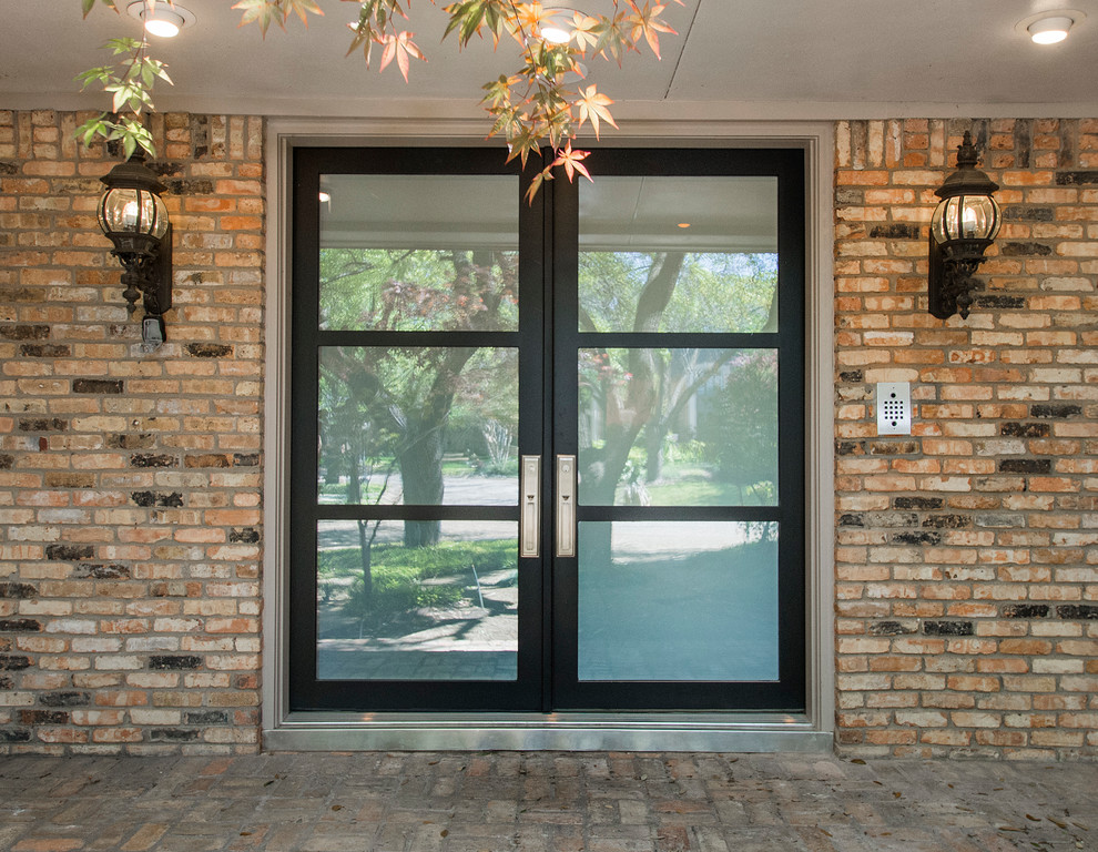 Cette image montre une porte d'entrée design de taille moyenne avec un mur gris, un sol en bois brun, une porte double et une porte en verre.