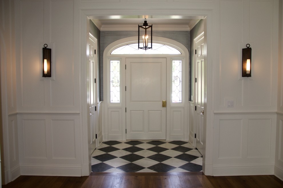 Ejemplo de distribuidor tradicional de tamaño medio con paredes blancas, suelo de madera en tonos medios, puerta simple, puerta blanca y suelo marrón