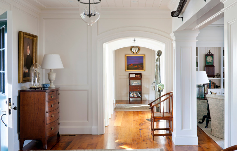 Inspiration for a large timeless medium tone wood floor entryway remodel in Boston with white walls