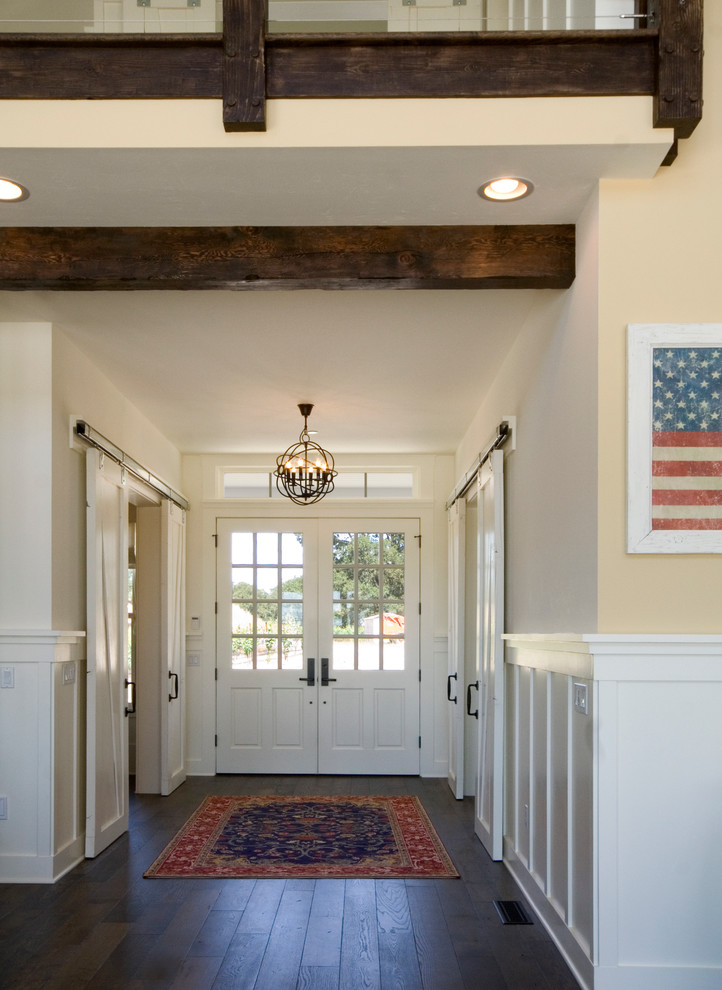 Foto de hall campestre de tamaño medio con paredes beige, suelo de madera oscura, puerta doble y puerta blanca