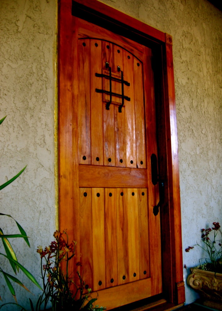 Ejemplo de puerta principal mediterránea de tamaño medio con paredes beige, puerta simple y puerta de madera en tonos medios