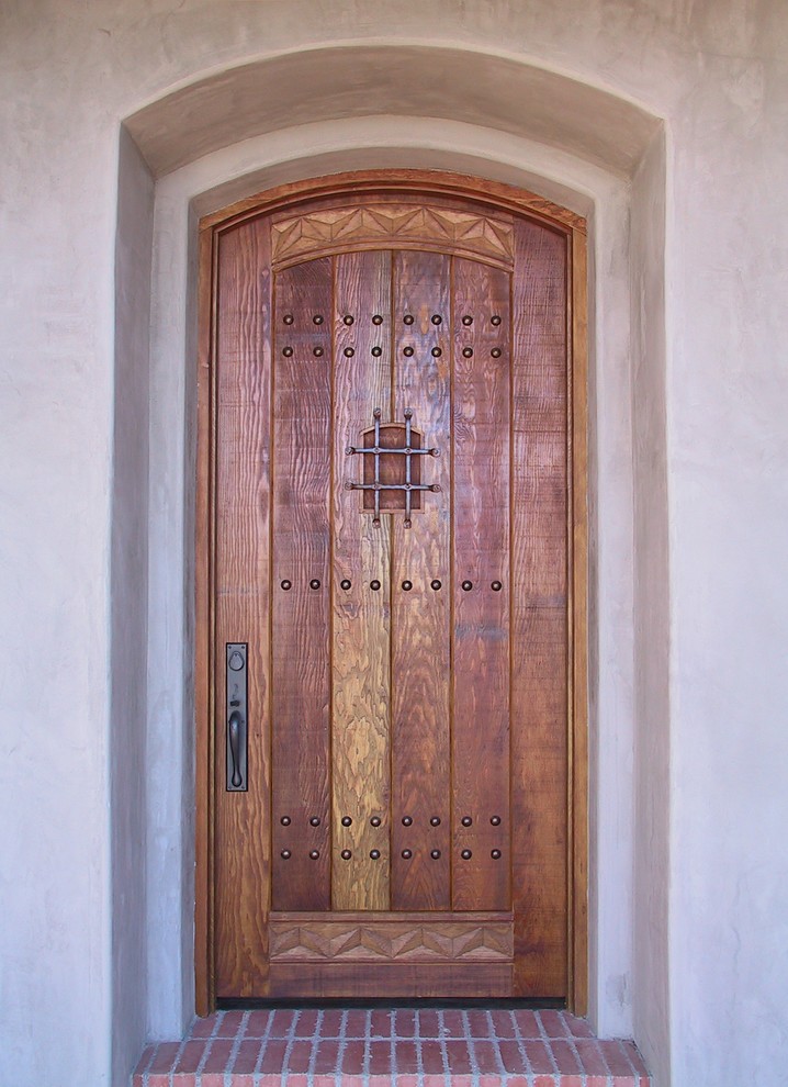 Cette image montre une grande porte d'entrée chalet avec un mur beige, une porte simple et une porte en bois brun.