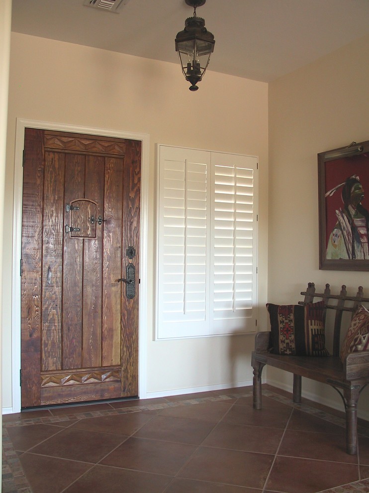 Esempio di una porta d'ingresso stile rurale di medie dimensioni con pareti beige, pavimento in terracotta, una porta singola e una porta in legno bruno