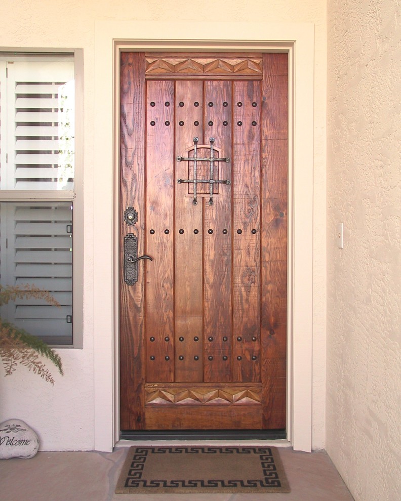 This is an example of a medium sized rustic front door in Phoenix with beige walls, terrazzo flooring, a single front door and a medium wood front door.