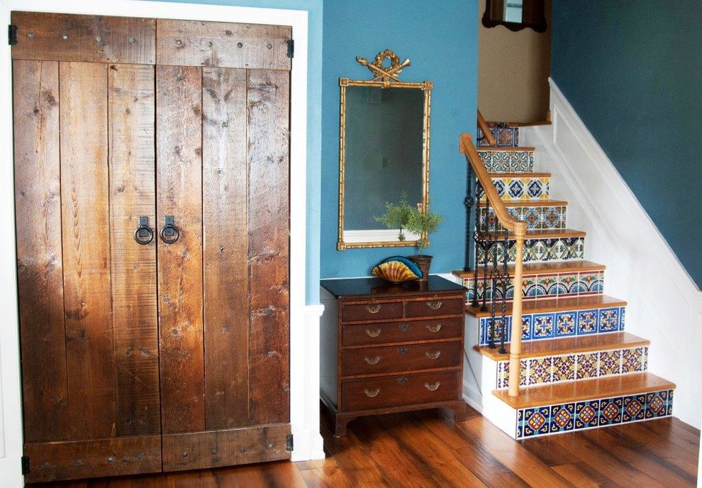 Esempio di un piccolo ingresso mediterraneo con pareti blu, pavimento in legno massello medio, una porta singola e una porta in legno scuro