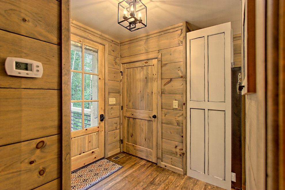 На фото: маленькое фойе в стиле рустика с серыми стенами, деревянным полом, одностворчатой входной дверью, серой входной дверью и коричневым полом для на участке и в саду с