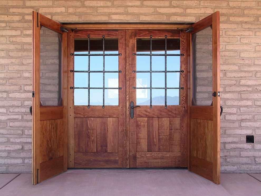Свежая идея для дизайна: большая входная дверь в стиле рустика с коричневыми стенами, бетонным полом, двустворчатой входной дверью и входной дверью из дерева среднего тона - отличное фото интерьера