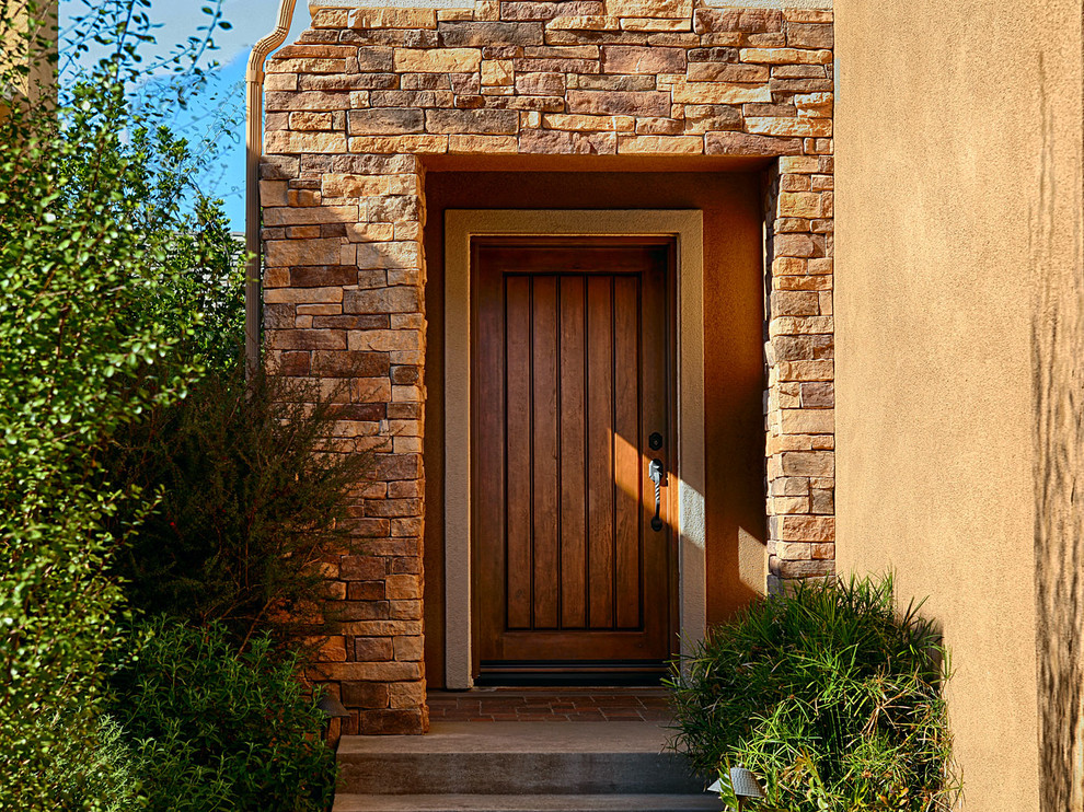 Idee per una grande porta d'ingresso rustica con pareti marroni, una porta singola e una porta in legno chiaro
