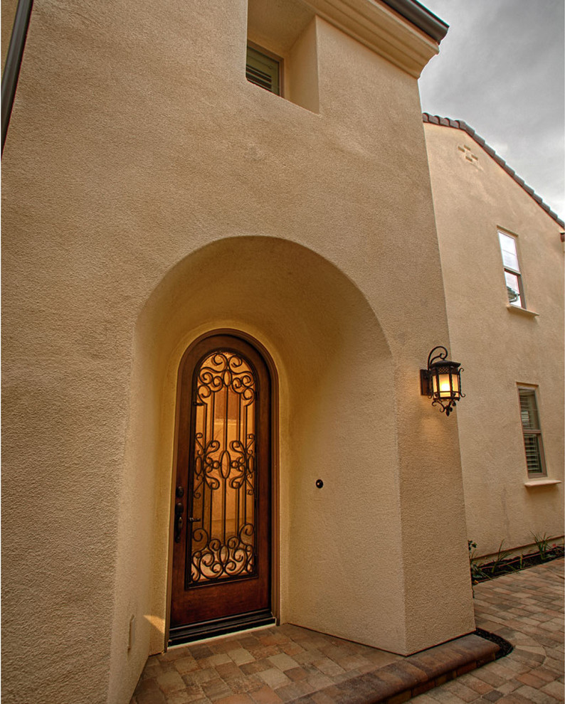 Rustik inredning av en mellanstor ingång och ytterdörr, med gula väggar, en enkeldörr och glasdörr