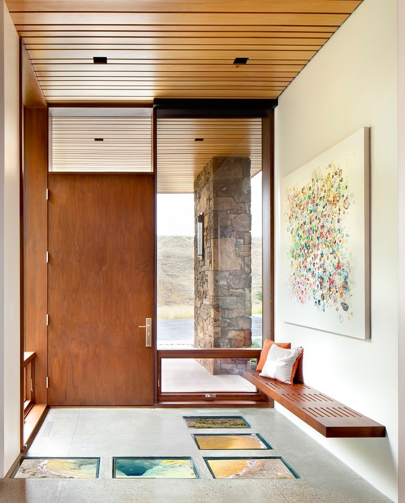 Foto de entrada rústica con paredes blancas, puerta simple, puerta de madera en tonos medios y suelo gris