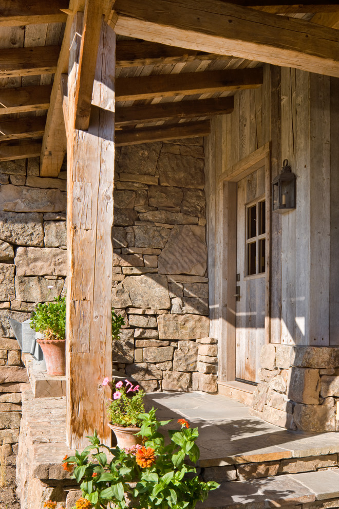 Diseño de entrada rústica con puerta simple y puerta de madera en tonos medios