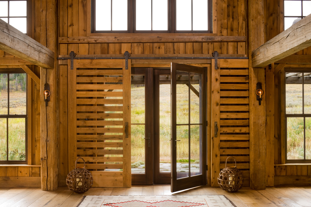 Foto de puerta principal rústica con suelo de madera en tonos medios y puerta doble