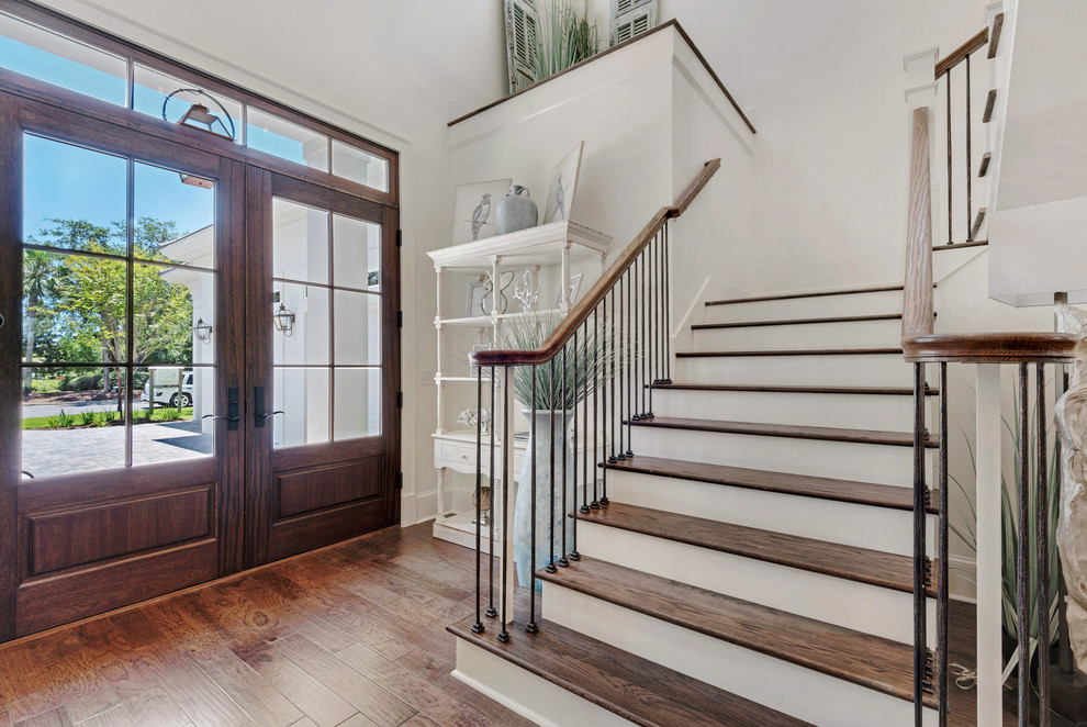 Großes Landhaus Foyer mit weißer Wandfarbe, braunem Holzboden, hellbrauner Holzhaustür und Doppeltür in Sonstige