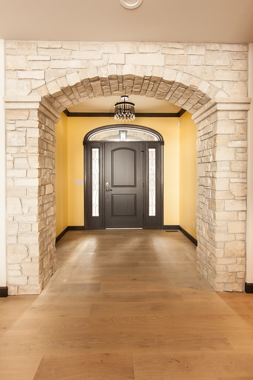 Ispirazione per una porta d'ingresso stile americano di medie dimensioni con pareti gialle, parquet chiaro, una porta singola e una porta nera