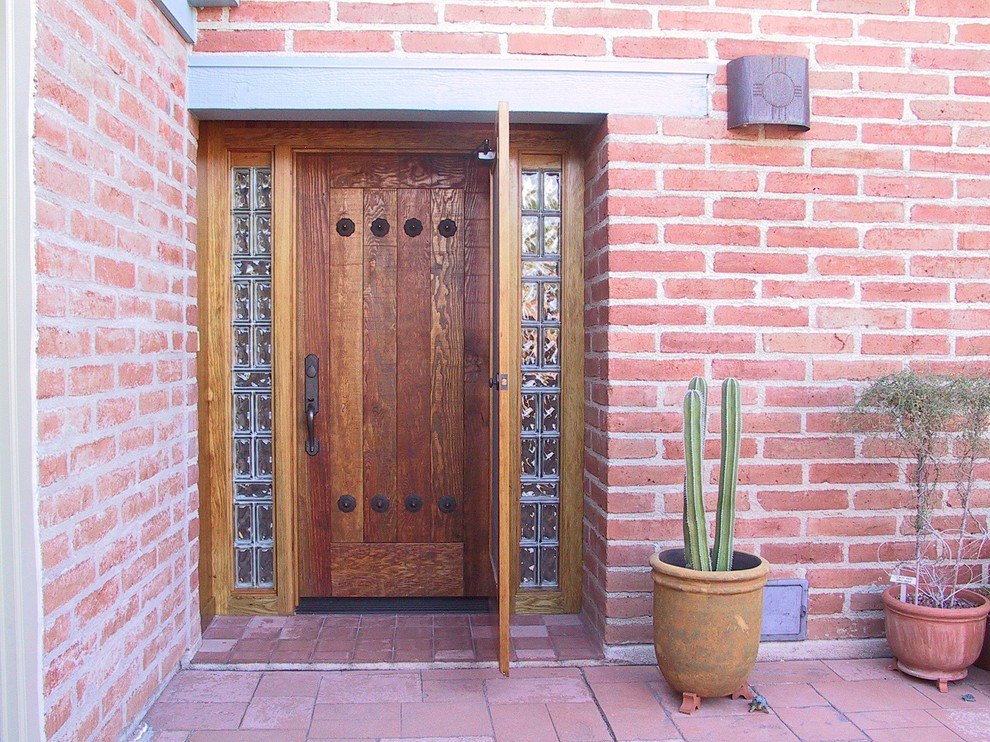 Inspiration pour une porte d'entrée chalet de taille moyenne avec un mur rouge, une porte simple et une porte en bois brun.