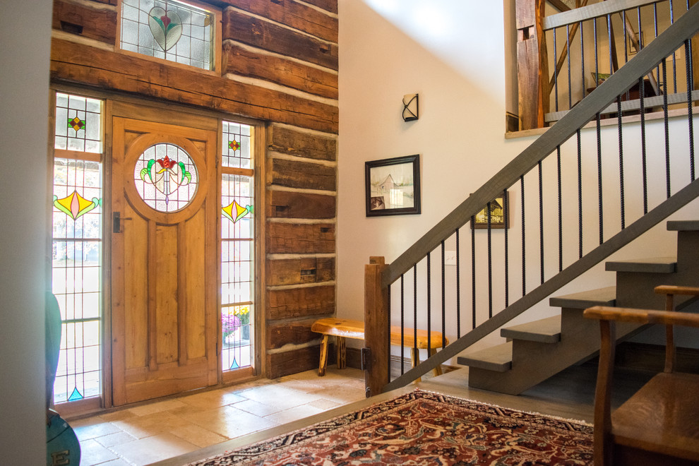 Rustikaler Eingang mit weißer Wandfarbe, Einzeltür, hellbrauner Holzhaustür und beigem Boden in Sonstige