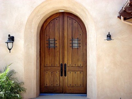 Cette photo montre une porte d'entrée méditerranéenne avec une porte double et une porte en bois foncé.