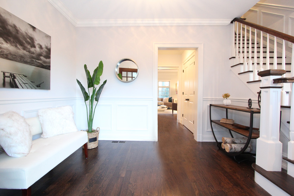 Cette photo montre un hall d'entrée chic de taille moyenne avec un mur gris, parquet foncé, une porte simple et une porte en bois foncé.