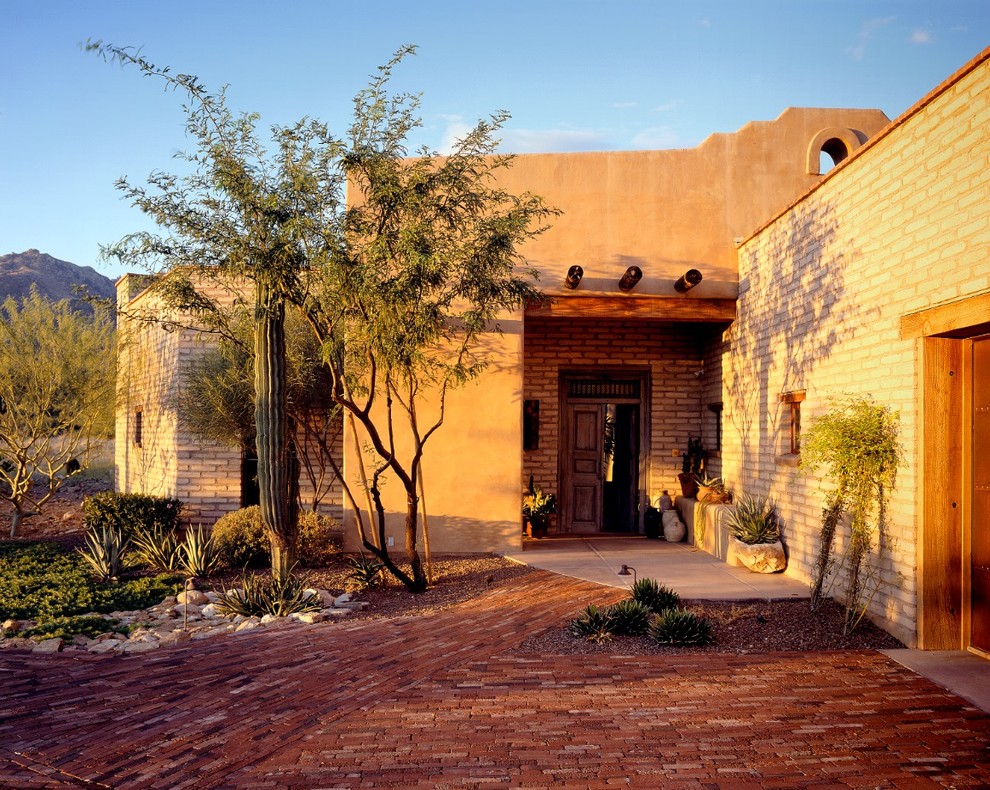 Immagine di una grande porta d'ingresso minimal con pareti beige, pavimento in cemento, una porta a due ante e una porta verde