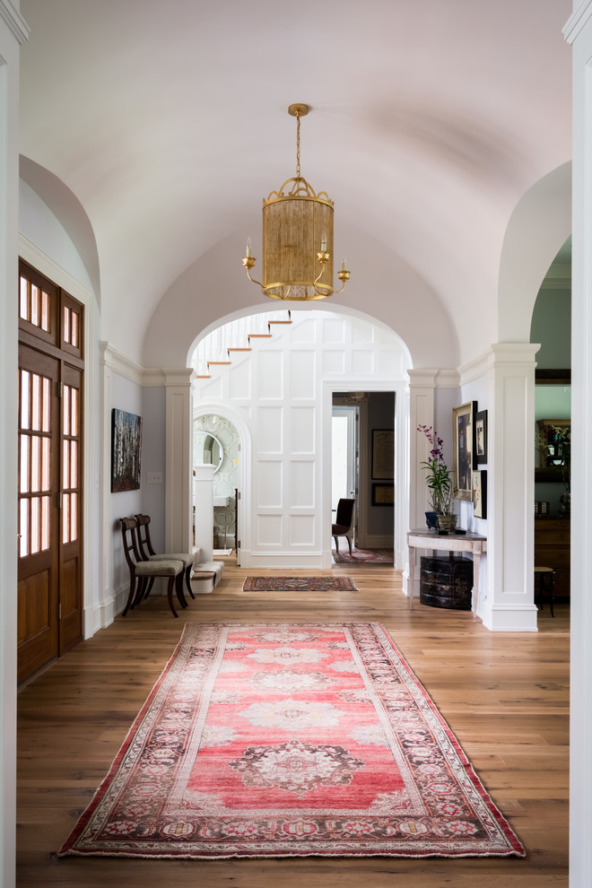 This is an example of a classic foyer in Richmond with white walls, medium hardwood flooring, a single front door, a medium wood front door and brown floors.