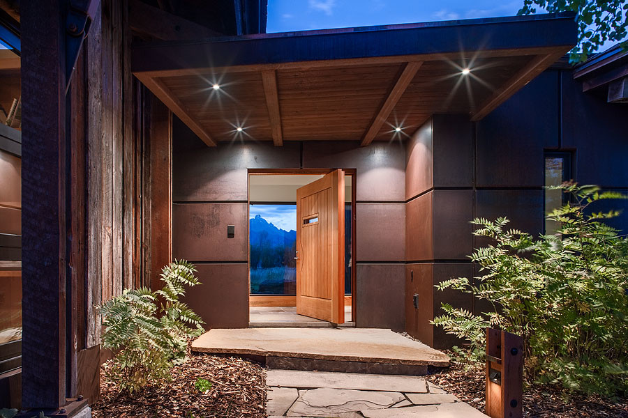 Стильный дизайн: входная дверь в современном стиле с серебряными стенами, полом из сланца, поворотной входной дверью и входной дверью из дерева среднего тона - последний тренд