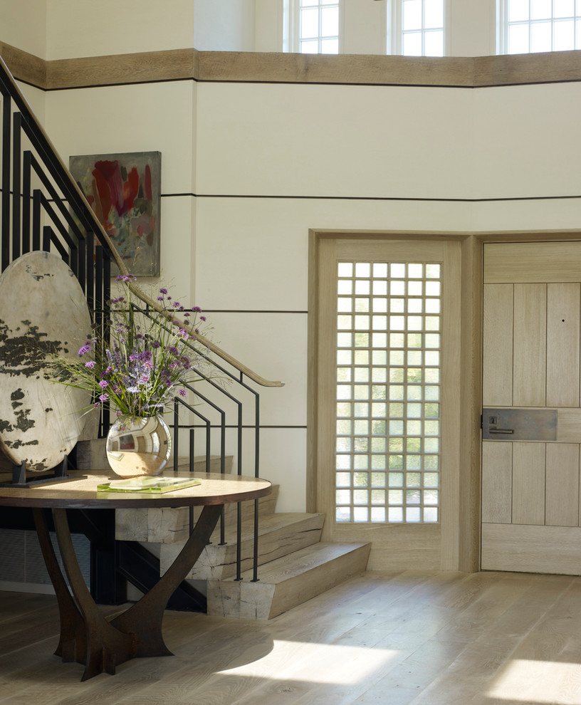 Immagine di un ingresso stile marinaro con pareti beige, parquet chiaro, una porta singola e una porta in legno chiaro