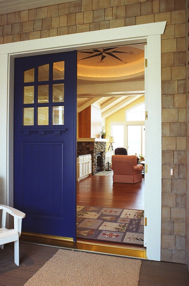 Inredning av en klassisk mellanstor foajé, med bruna väggar, mellanmörkt trägolv, en enkeldörr och en blå dörr
