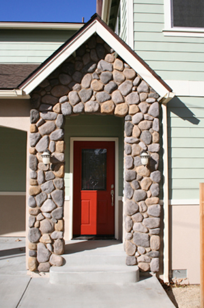 Exempel på en mellanstor klassisk ingång och ytterdörr, med gröna väggar, betonggolv, en enkeldörr och en röd dörr