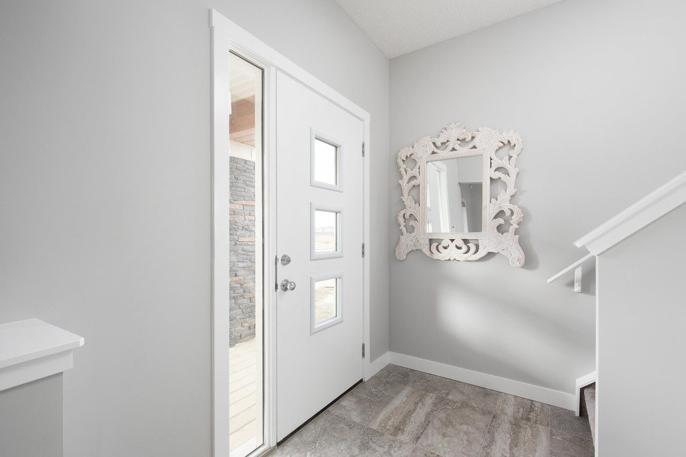 Kleiner Klassischer Eingang mit Korridor, grauer Wandfarbe, Keramikboden, Drehtür und weißer Haustür in Calgary