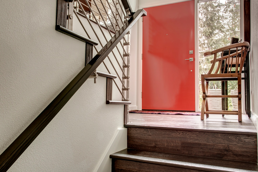 Immagine di un ingresso con vestibolo contemporaneo con pareti bianche, pavimento in legno massello medio, una porta singola e una porta rossa