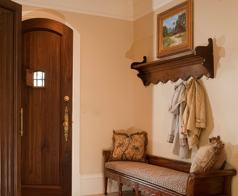 Small tuscan dark wood floor entryway photo in Houston with beige walls and a dark wood front door