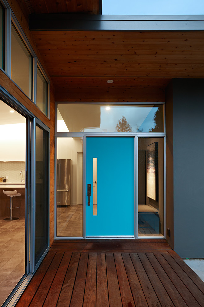 На фото: входная дверь среднего размера в стиле ретро с темным паркетным полом, одностворчатой входной дверью, синей входной дверью и коричневым полом с