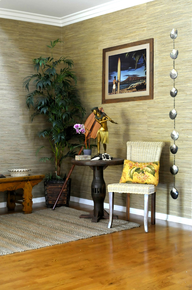 Foto på en mellanstor tropisk hall, med flerfärgade väggar, mellanmörkt trägolv och en enkeldörr