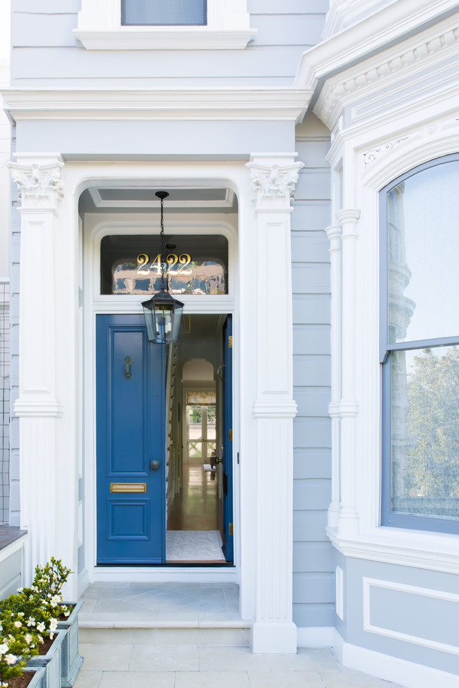 Cette photo montre une porte d'entrée victorienne avec une porte double et une porte bleue.