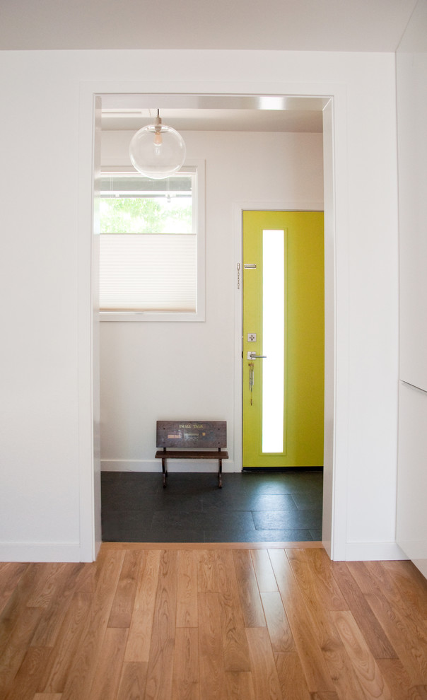 Modelo de distribuidor moderno de tamaño medio con paredes blancas, suelo de pizarra, puerta simple, puerta amarilla y suelo negro